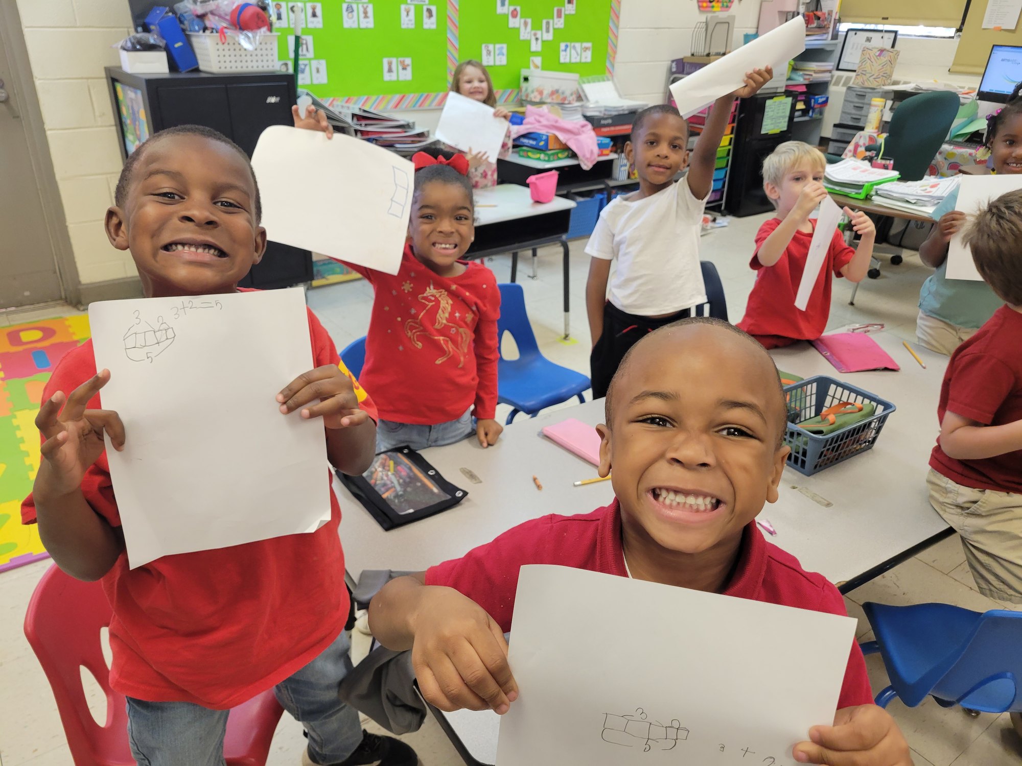 Kindergarten students holding up their finished work